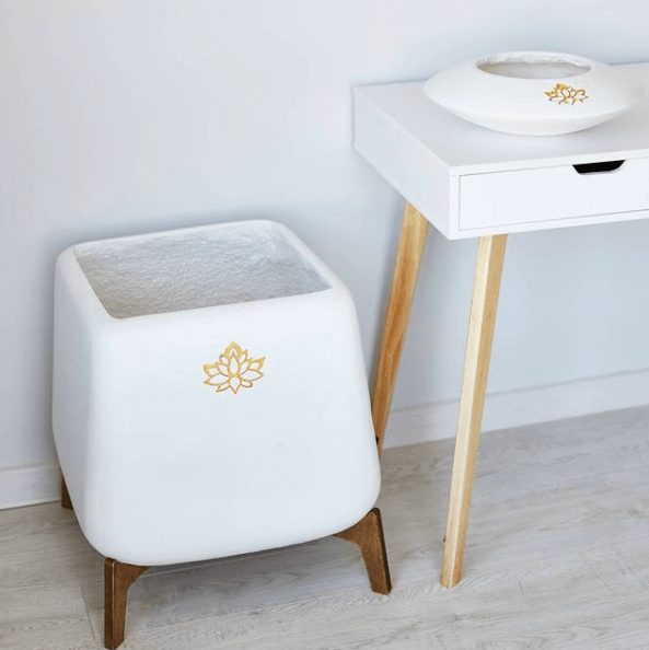 White clay planter with golden lotus on wooden stand by Sparkle Stone