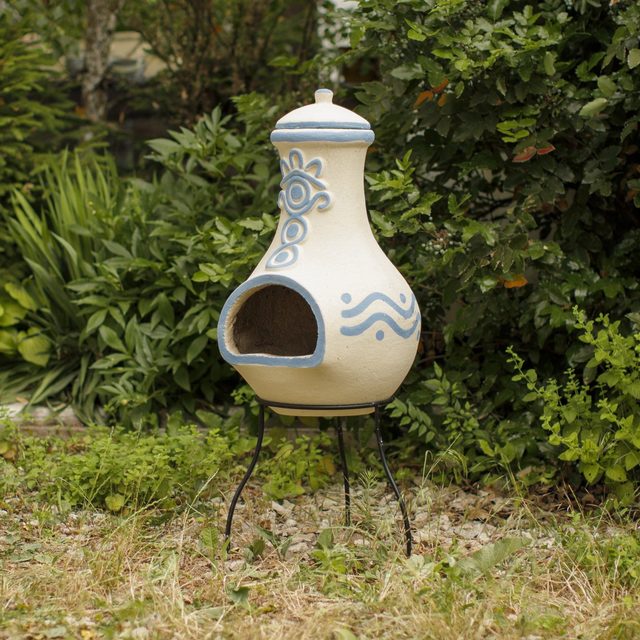 Blue clay chiminea by Sparkle Stone in the garden, with protective lid