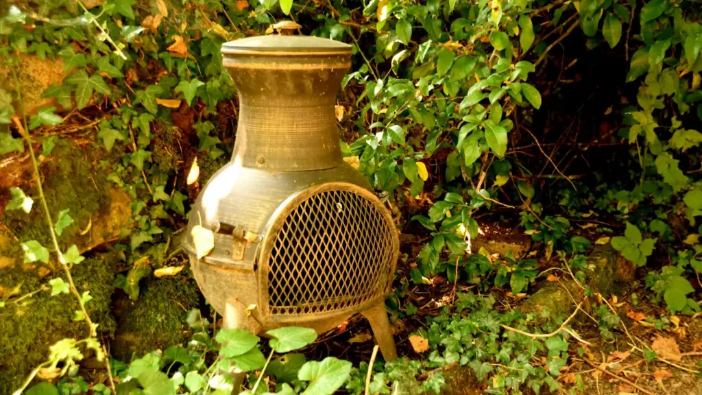 Cast iron chiminea standing in a garden among ivy